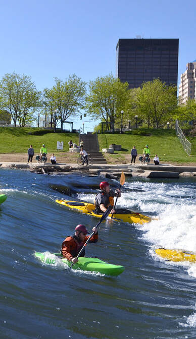 Kayakers on the Great Miami River in front of the Dayton skyline